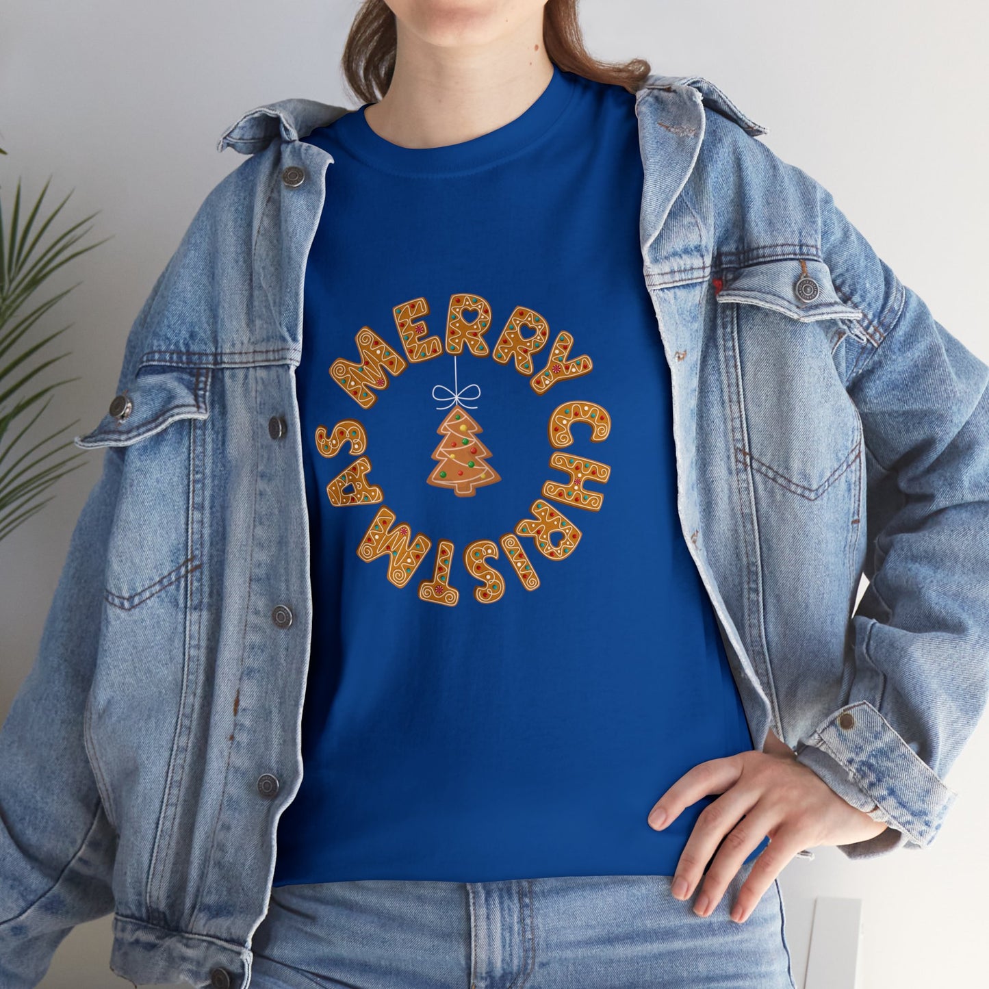 Holiday, Christmas. A woman is wearing a Christmas t-shirt with a wreath made out of gingerbread cookies and spells out Merry Christmas. A Christmas tree cookie dangles in the middle of the wreath.