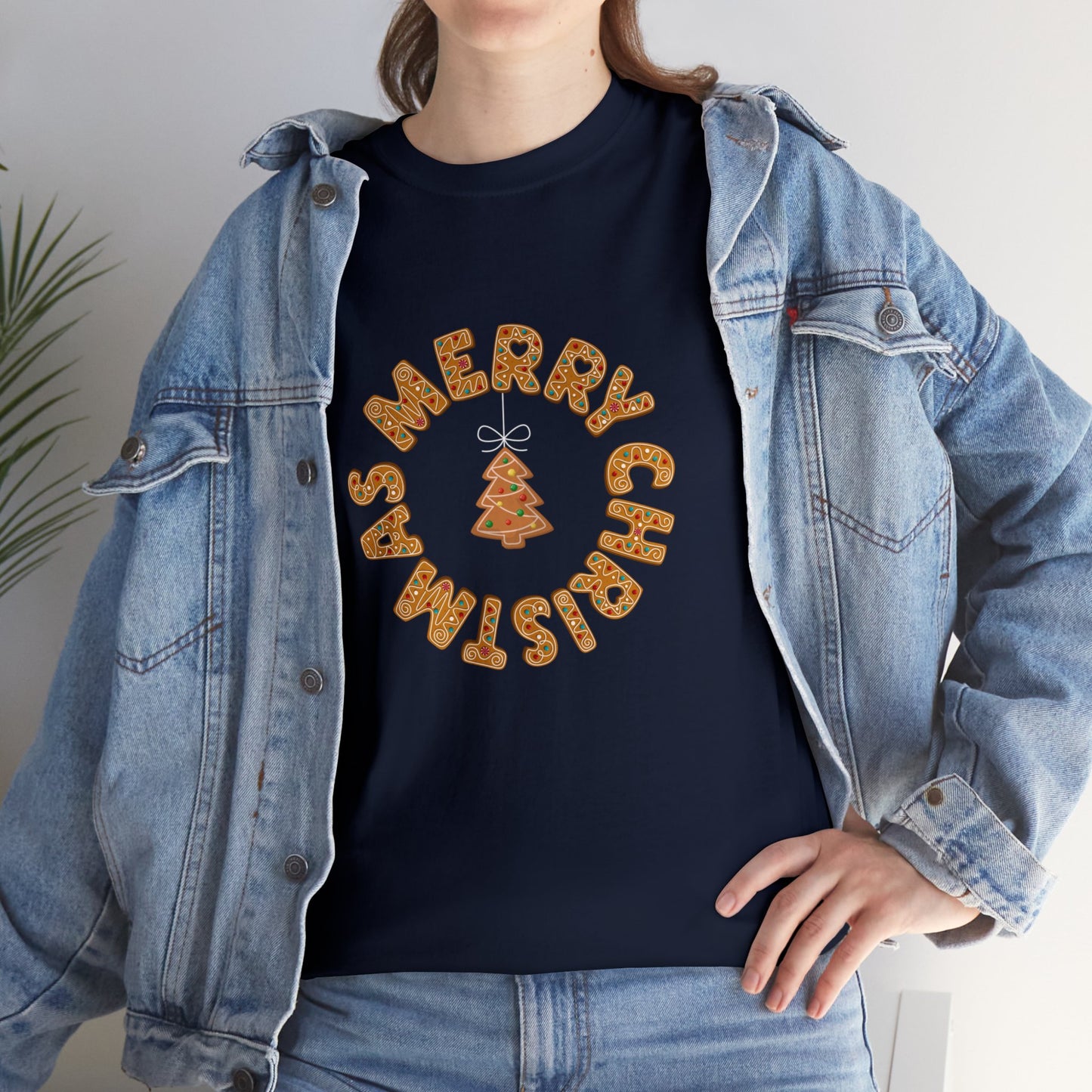 Holiday, Christmas. A woman is wearing a Christmas t-shirt with a wreath made out of gingerbread cookies and spells out Merry Christmas. A Christmas tree cookie dangles in the middle of the wreath.