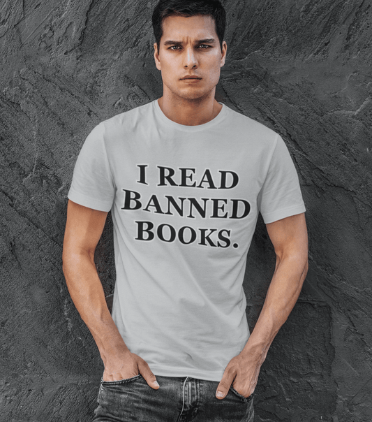 Handsome man leaning against a wall wearing a t-shirt that reads, I Read Banned Books.