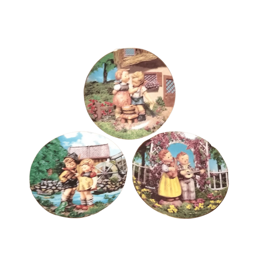 M.J. Hummel  Little Companions Plates With Boy And Girl Hummels Singing And Dancing.  Danbury Mint  Fine Porcelain.  Gold Trim.  Made in Switzerland. 