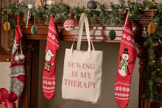 Sewing is my therapy canvas bag hanging on a hook over a fireplace with Christmas stockings.