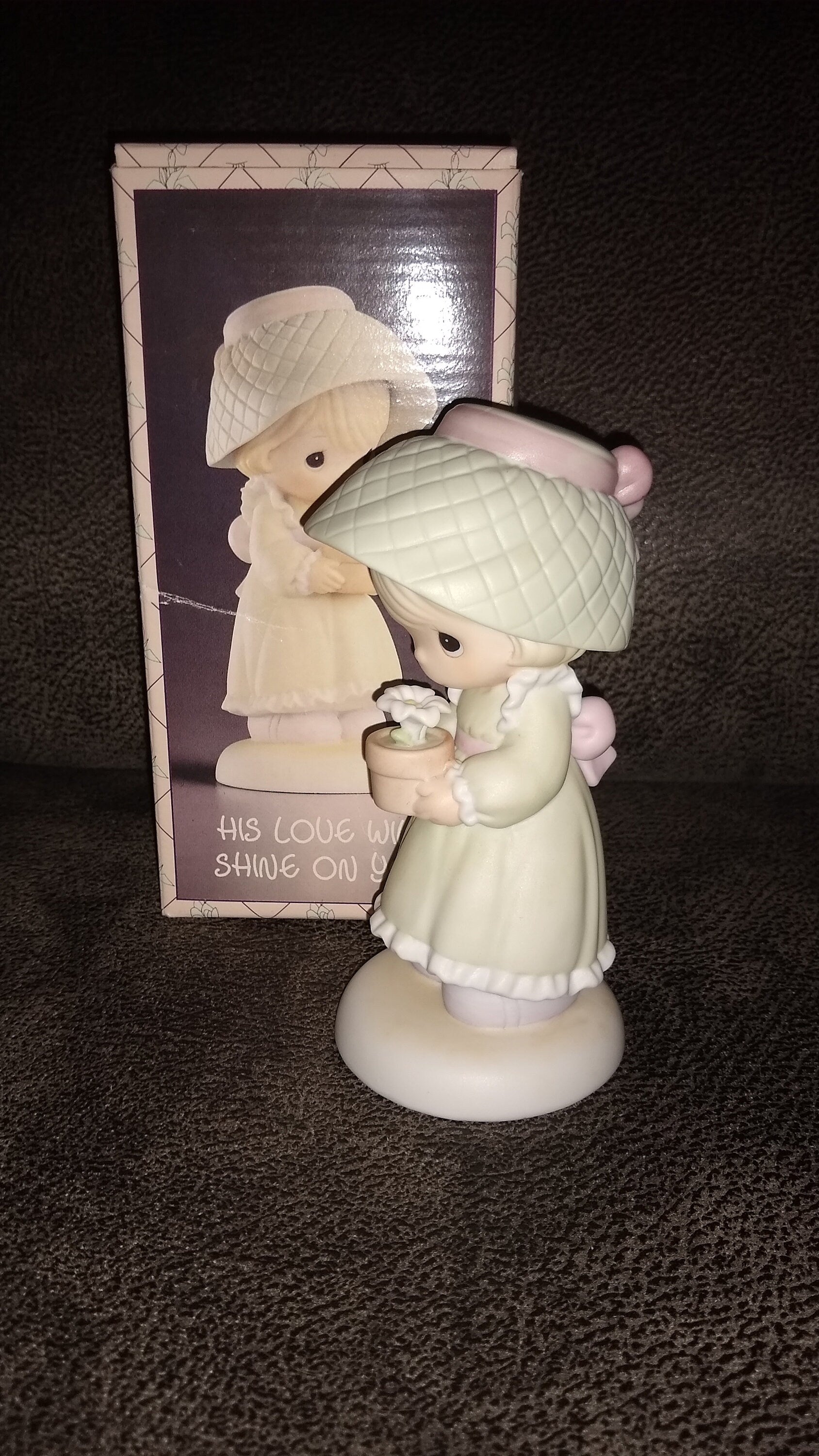 Precious Moments Figurine By Enesco.  His Love Will Shine On You Figurine Featuring A Woman Holding A Flower Pot With Flowers.