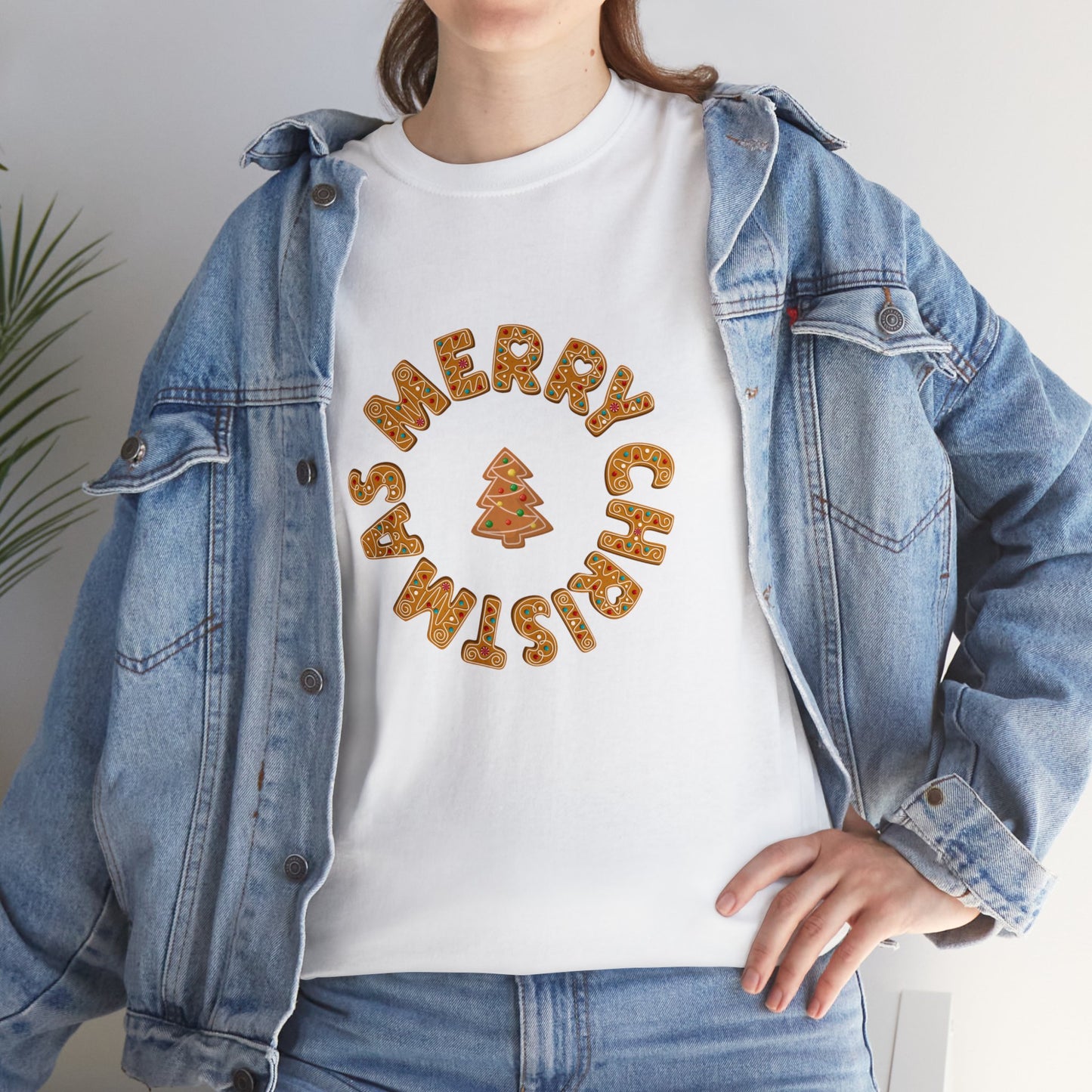 Holiday, Christmas. A woman is wearing a Christmas t-shirt with a wreath made out of gingerbread cookies and spells out Merry Christmas. A Christmas tree cookie dangles in the middle of the wreath.