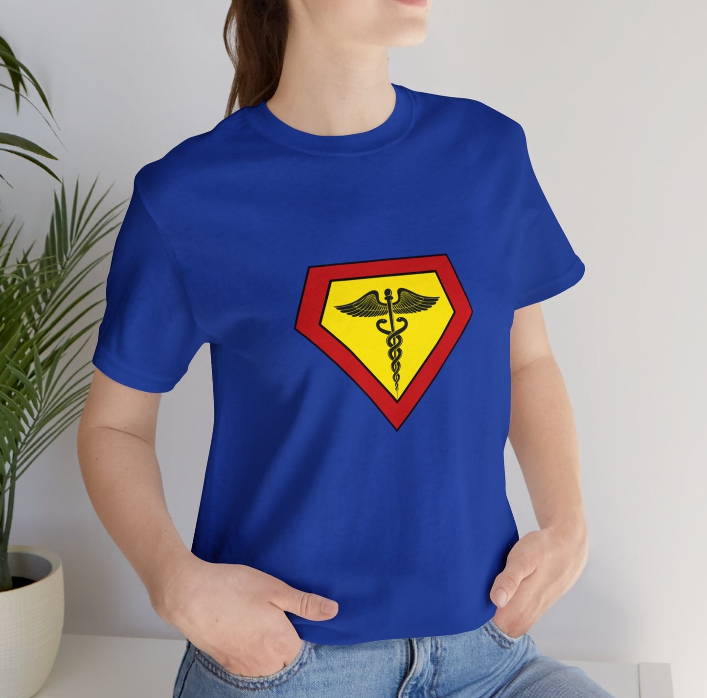Occupation, Doctor, Medical Worker. Woman wearing a superhero style medical symbol on a t-shirt.