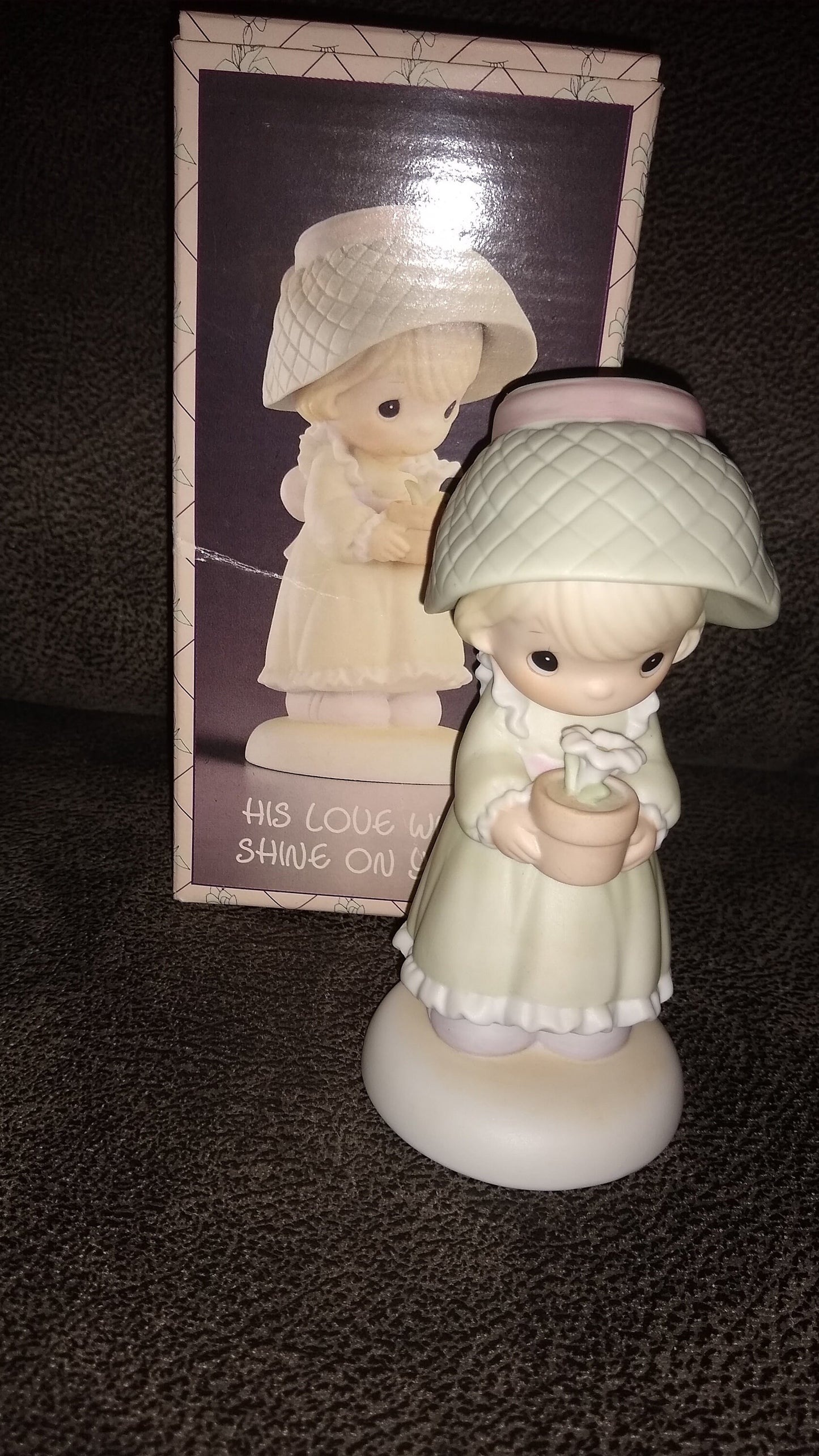 Precious Moments Figurine By Enesco.  His Love Will Shine On You Figurine Featuring A Woman Holding A Flower Pot With Flowers.