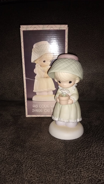 Precious Moments Figurine By Enesco.  His Love Will Shine On You Figurine Featuring A Woman Holding A Flower Pot With Flowers.